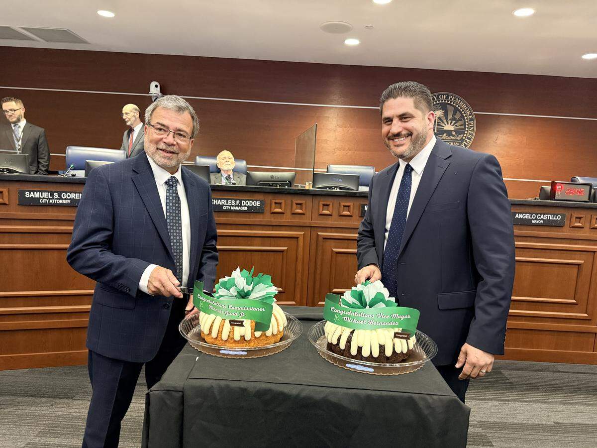 District 1 Commissioner Thomas Good, left, and District 4 Commissioner Michael Hernandez cut a cake following their swearing-in ceremonies during the March 18 Pembroke Pines City Commission meeting.