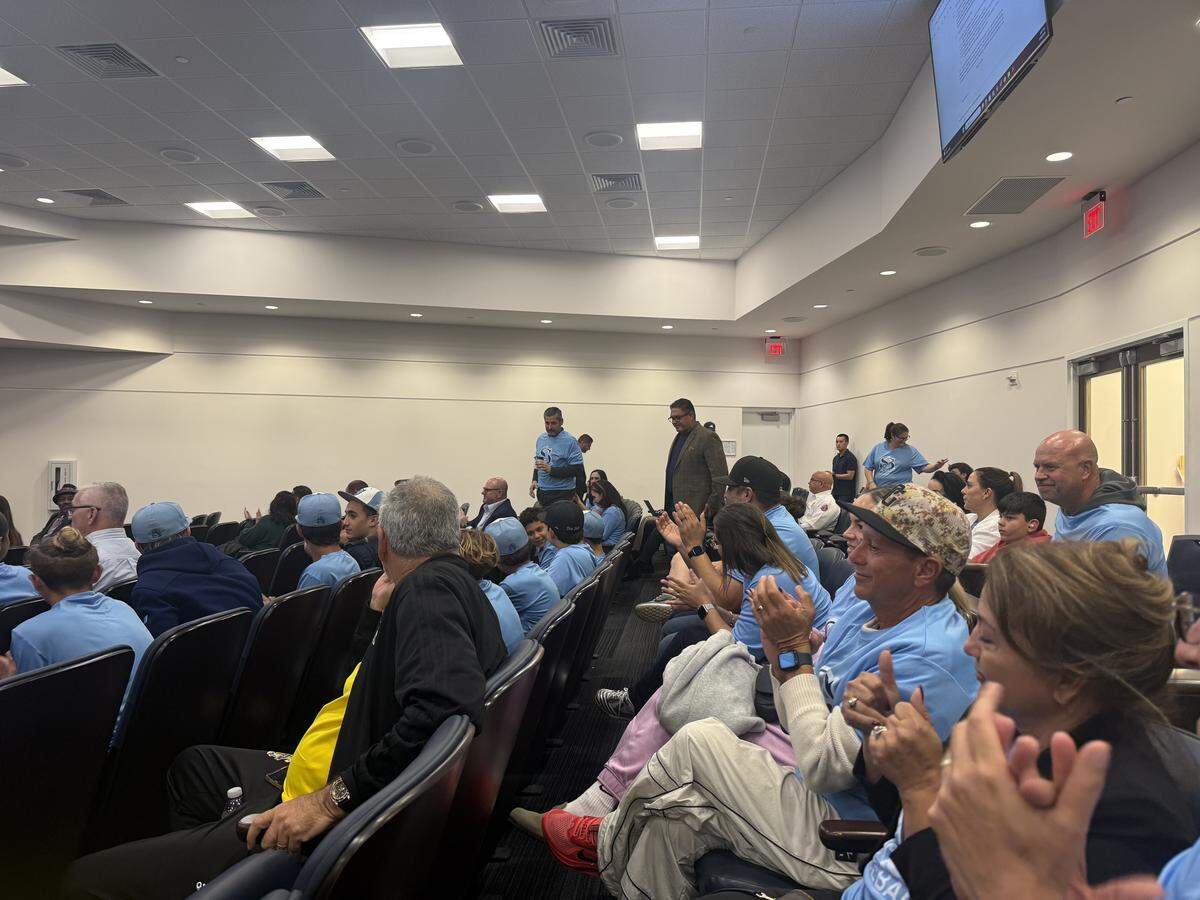 Somerset Academy parents and students applaud in the commission chambers after officials approved a 10-year agreement for an artificial turf field.