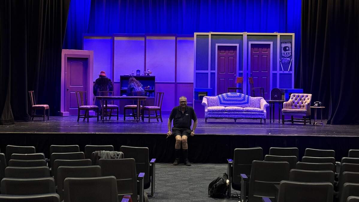 Director Jerry Jensen sitting on stage before rehearsal for “Broadway Bound” starts.