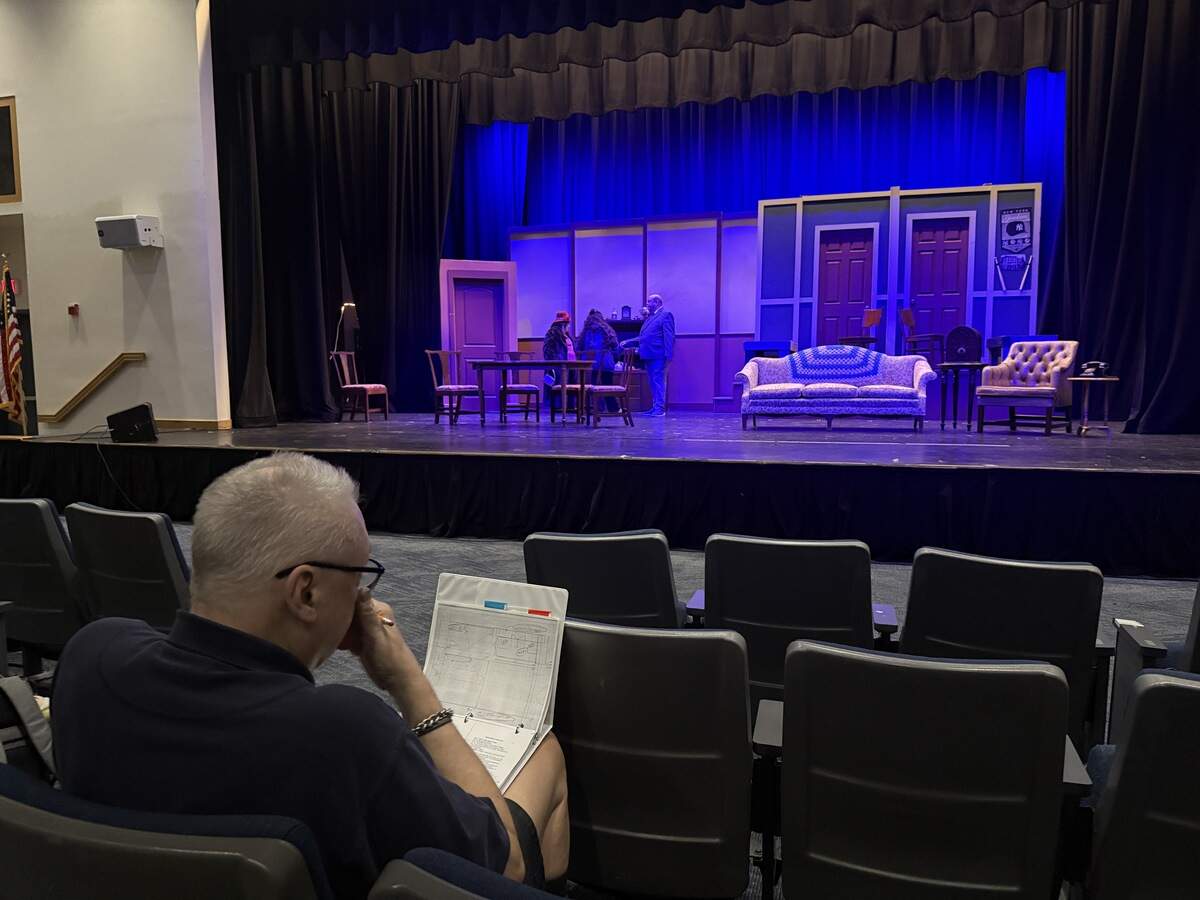 Director Jerry Jensen sitting in the audience as the cast prepares for its first run through the show.