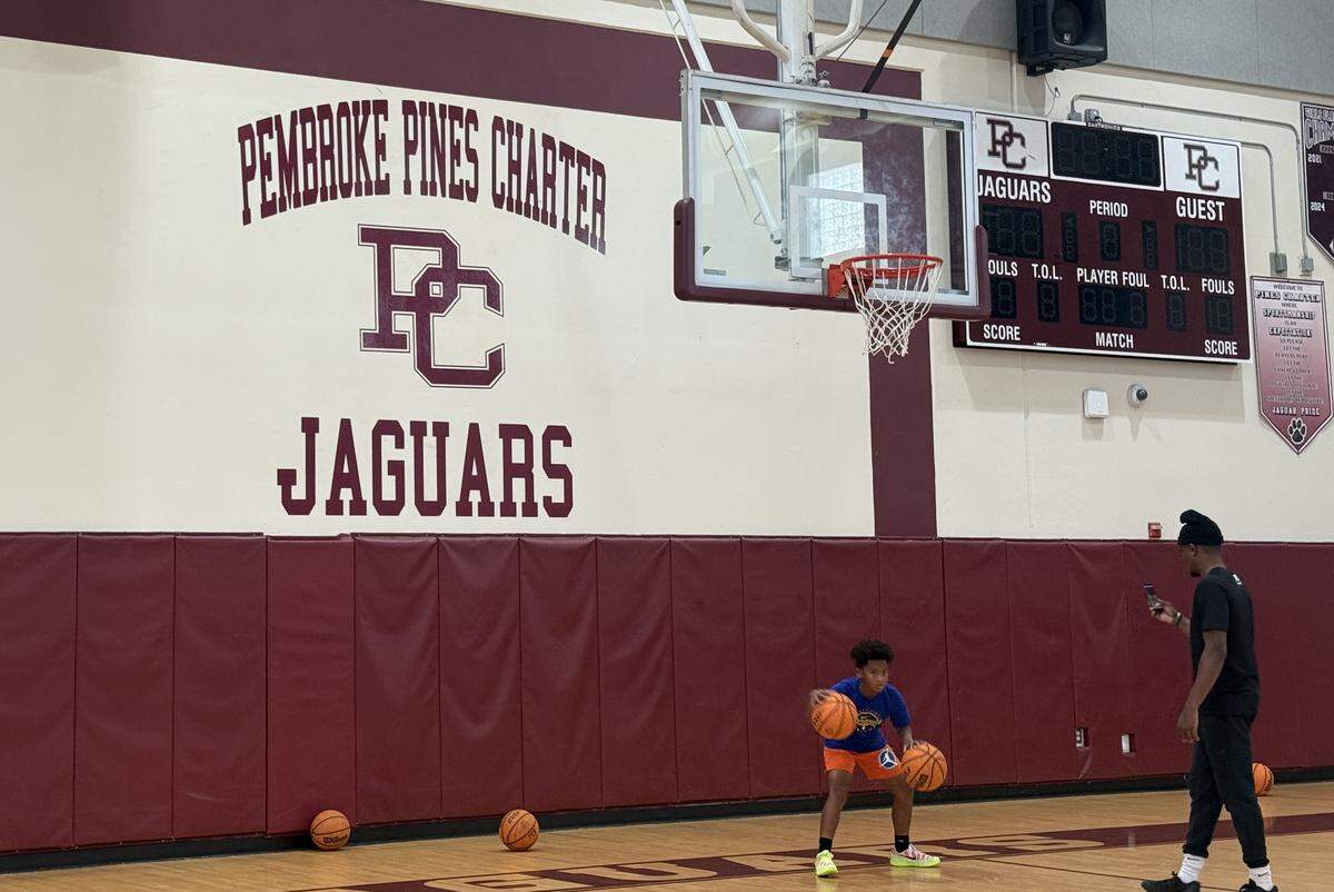 The Jaguars logo inside the Pembroke Pines Charter High School gymnasium as a youth basketball camp player practices.