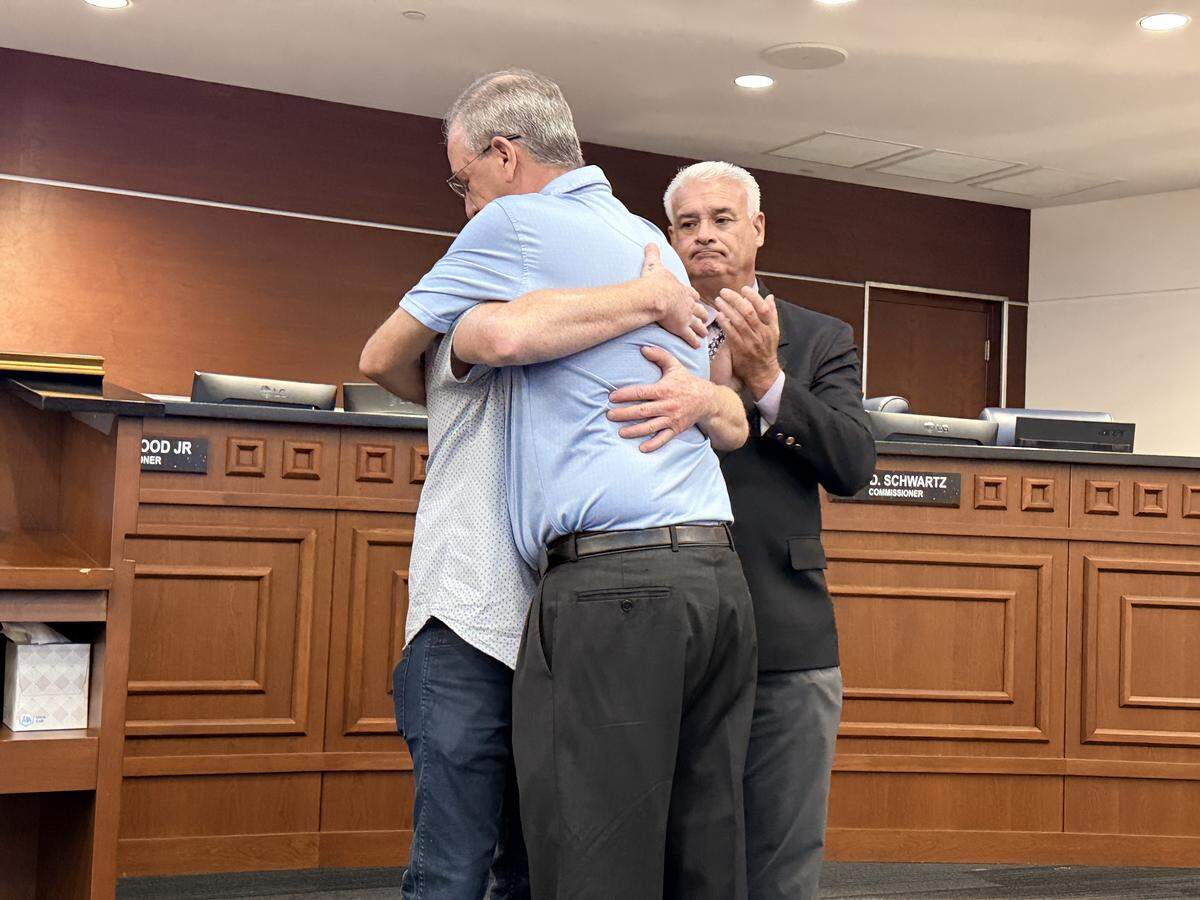 Commissioner Jay D. Schwartz embraces Nathan Ganter during the June 3 City Commission meeting.
