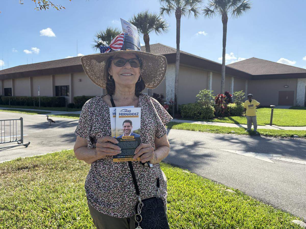 Resident Ana Butaric canvasses for incumbent District 4 Commissioner Mike Hernandez outside the Century Village Clubhouse polling site, located at 13300 SW 10th St.