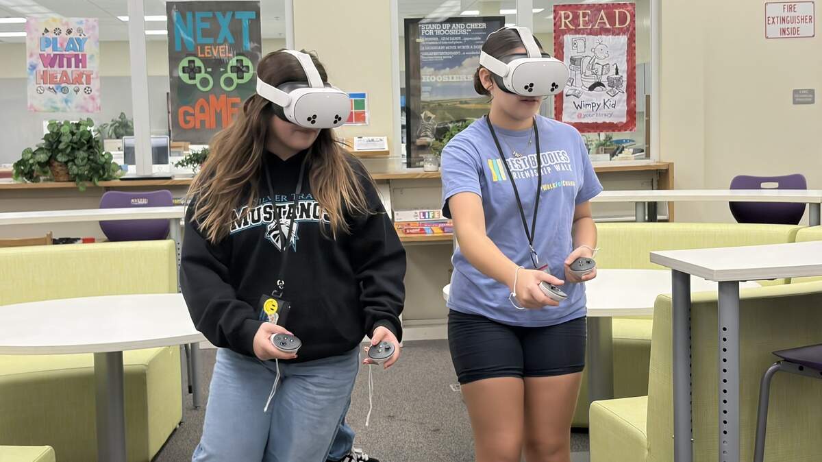 Seventh grader Syndey Musarra, left, and eighth grader Veronica Zambrano, right, demonstrate how to use Silver Trail Middle School’s new extended reality devices.