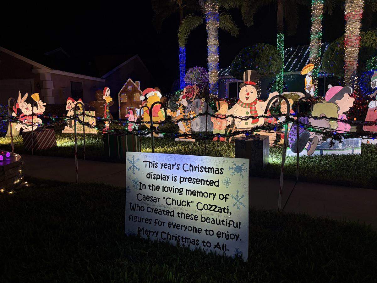 A sign dedicated to Lisa Sumby’s father, Caesar Cozatti, who hand-painted most of the Sumby family’s plywood figures on display at their home